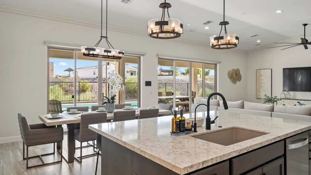 A modern kitchen with a large island, pendant lighting, and a view to the outside. - Pool & Spa | 70ft RV Garage | Near Riviera Marina (Lake Havasu City)
