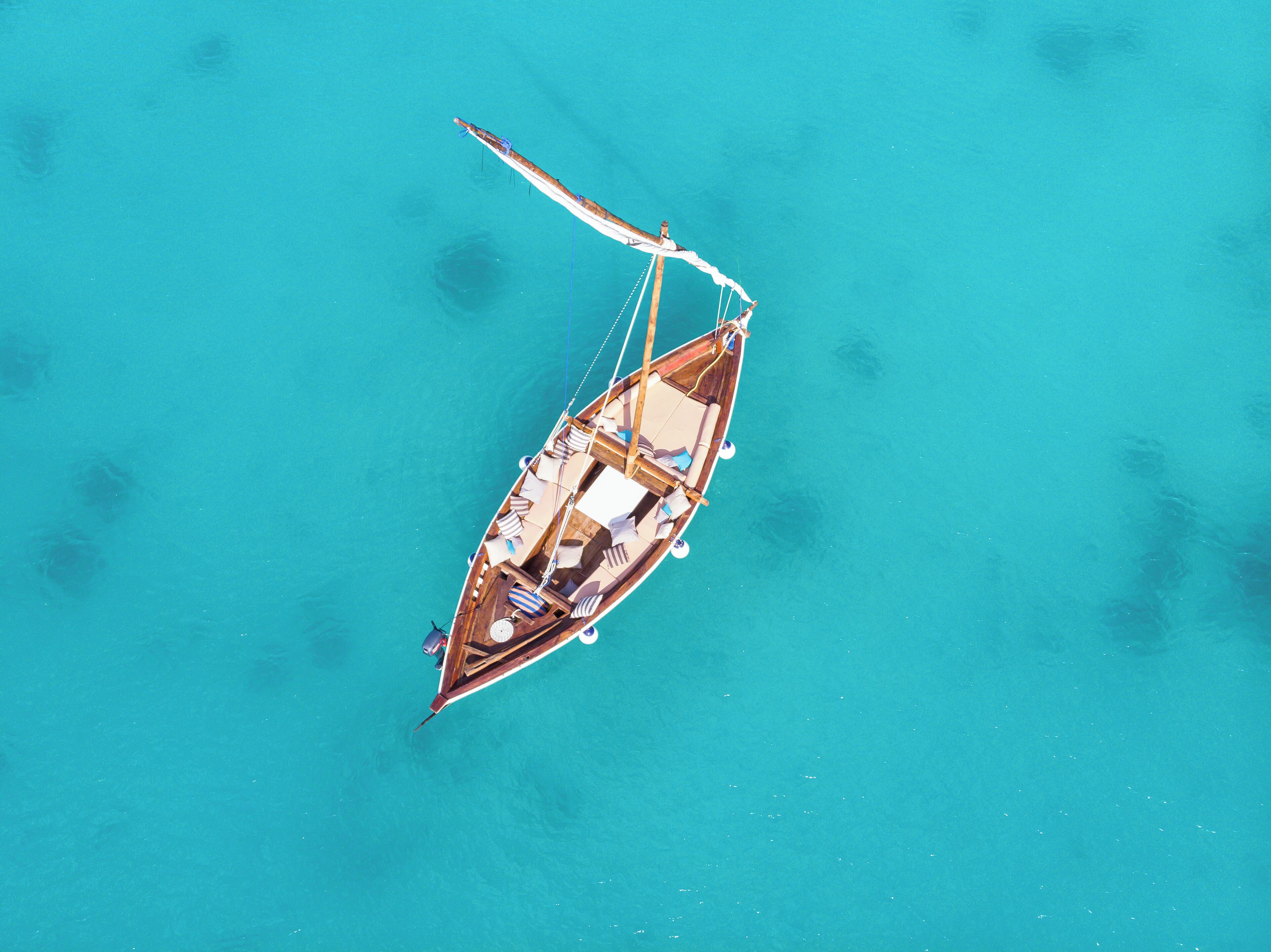 Un pequeño barco con cabina y zona de estar, flotando sobre aguas turquesas.