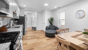 Una cocina moderna con estufa a gas, un lavamanos y un comedor con mesa y sillas.
