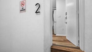 Un pasillo con un cartel de 'No Fumar' y el número '2' en la pared.