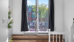 A balcony with a view of a playground and trees.