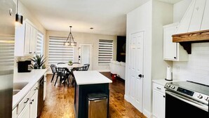A modern kitchen with white cabinetry, a central island, and a built-in oven. - Pickleball + Pool + Bkyd Oasis + Centrally Located (Frisco)