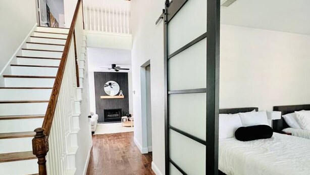 A hotel room with a sliding glass door, a wooden staircase, and a fireplace. - Pickleball + Pool + Bkyd Oasis + Centrally Located (Frisco)