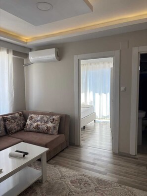 A modern living room with a sofa, a coffee table, and a patterned rug. - Maraş Blue Life Suite (Kahramanmaras)