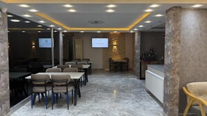 A conference room with a marble floor, tables, chairs, and a projection screen. - Maraş Blue Life Suite (Kahramanmaras)