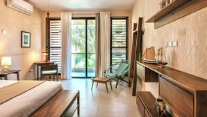 Habitación de hotel con cama, una silla, una mesita, estante con adornos y vistas al exterior a través de una puerta corrediza.