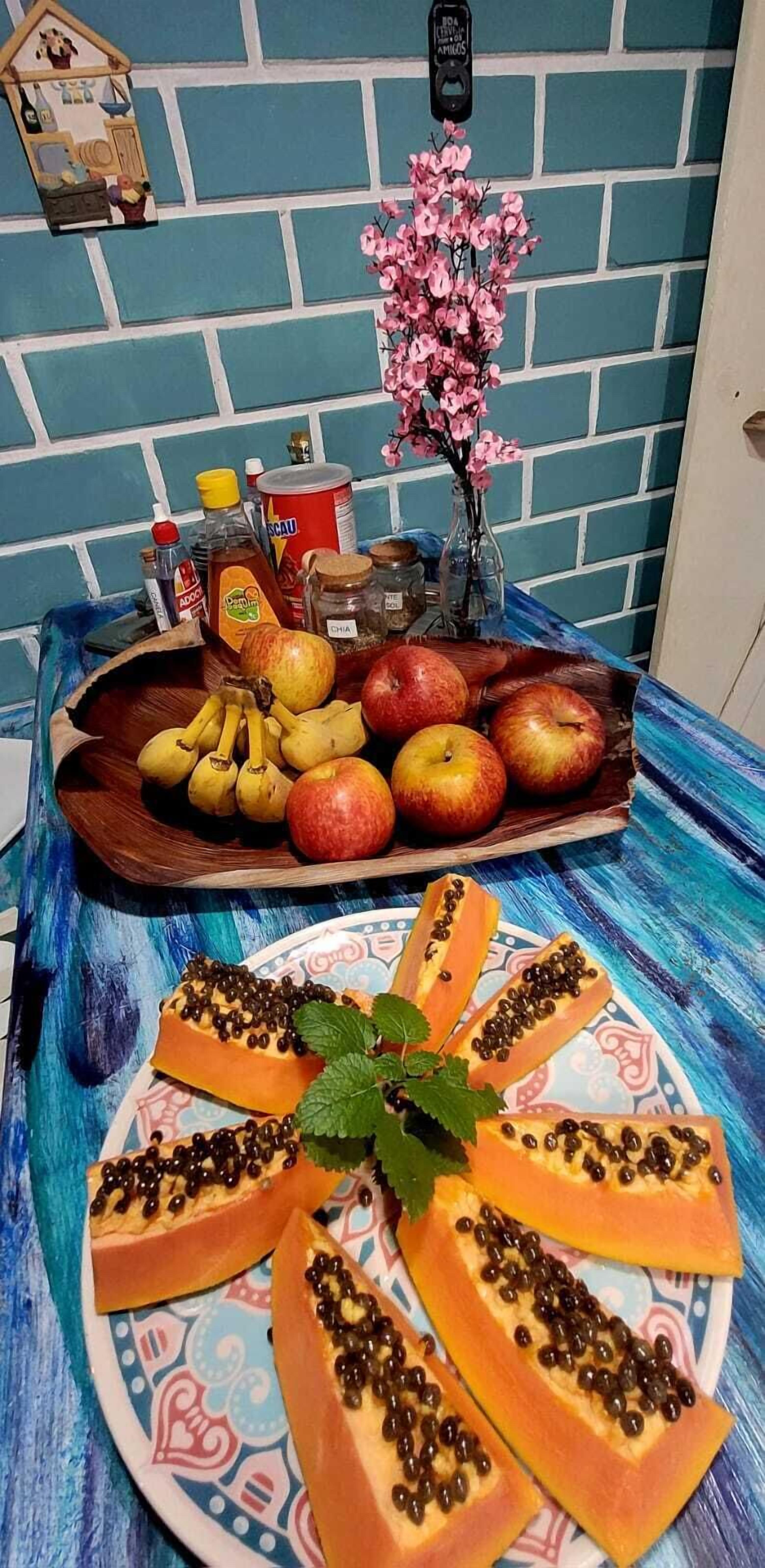 Ein Tisch mit verschiedenen Früchten und einem dekorativen, hausähnlichen Gegenstand.