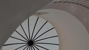 A spiral staircase with a circular ceiling design. - al sahafah gate hotel (Riyadh)