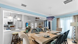 Cozinha moderna com armários brancos, micro-ondas e área de refeições com mesa e cadeiras de madeira.