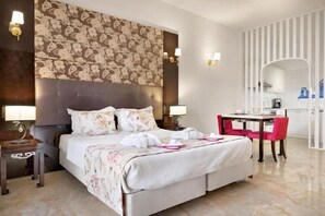 A hotel room with a large bed, a desk, and a chair. - Grand Muthu Oura View Beach Club (Albufeira)