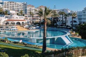 A resort with a large pool, palm trees, and modern buildings. - Grand Muthu Oura View Beach Club (Albufeira)