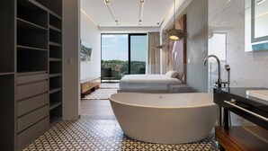 Une salle de bain moderne avec une baignoire sur pieds, un grand miroir et une douche intégrée.