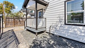 A house with a covered porch, a front door, and a large window. - Cozy & Bright 2BR Home - 10 Min to Downtown (Houston)