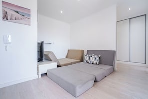 A modern bedroom with a bed, a TV, and a desk.