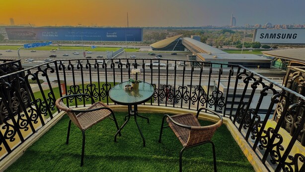 A balcony with a view of a highway, a modern building, and a Samsung sign. - Happy Hostel Dubai (Dubai)