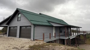 A two-story building with a green roof and a covered porch. - Secluded with amazing view (Jackson)