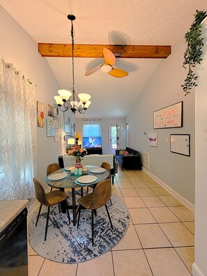 A dining area with a round table, chairs, a chandelier, and a ceiling fan. - Cozy Quiet North Raleigh Retreat/Private Deck. Dog-Friendly! (Raleigh)