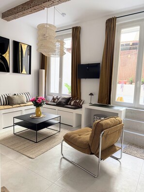 A modern living room with a sofa, a coffee table, a chair, and a TV.