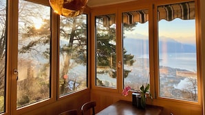 Une pièce dotée de grandes fenêtres, d’un plafond en bois et d’un luminaire suspendu.