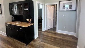 A spacious kitchen with dark cabinetry and a wooden countertop. - Iuka Downtown Historic King Loft B (Iuka)
