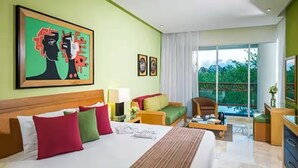 A hotel room with a large bed, a sofa, a desk, and a balcony with a view of trees. - New Year's- Dec 27th-Jan 3/2026- Luxury Resort- 2BR Grand Mayan Playa del Carmen (Solidaridad)