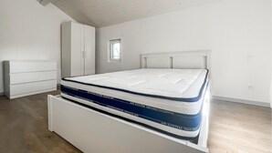 Ein Schlafzimmer mit einem Bett, einem Kleiderschrank und einem kleinen Fenster.