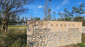 A stone sign with "TIMARRON" and "THE WOODLANDS" written on it.