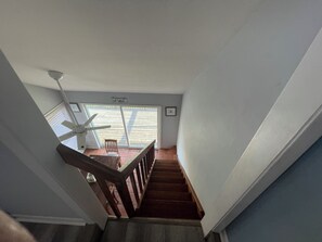 A staircase leading to a balcony with a ceiling fan and a sign that reads "Got Sandp".