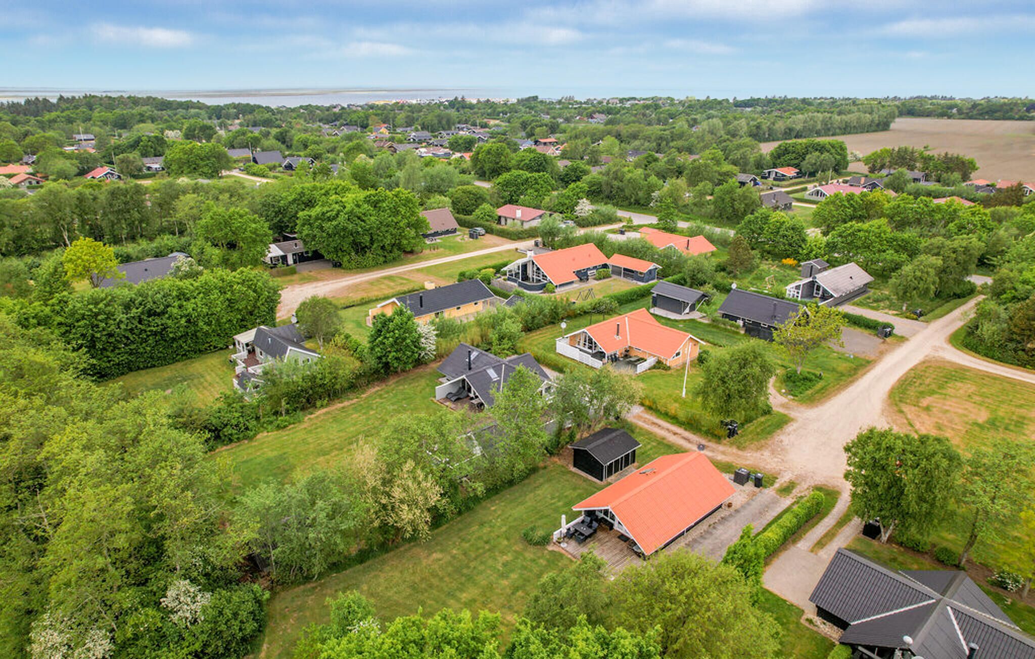 Vue aérienne d’un quartier résidentiel avec des maisons, des routes et de la végétation.