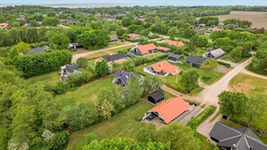 Vista aérea de uma área residencial com casas, ruas e vegetação.