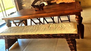 A rustic kitchen with a brick oven, wooden beams, and a large dining table. - Casa Magister Atalaia (Salinópolis)