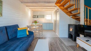 A compact living space with a sofa, a dining area, a kitchen, and a fireplace.