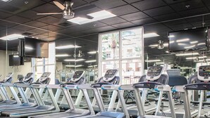 Ein Fitnessstudio mit Laufbändern, Kurzhanteln und Trainingsgeräten.