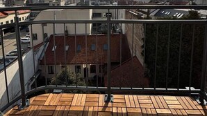Een dakterras met uitzicht op een stadsgezicht, met gebouwen en een heldere lucht.