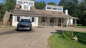 A two-story house with a covered porch, a driveway, and a car parked in front. - Newly renovated 3-bedroom 2 bath pet friendly unit on Barclay Mountain. (Monroe)