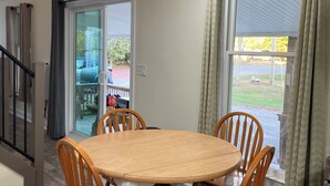 A dining area with a wooden table and chairs, a sliding glass door leading outside, and a staircase to the left. - Newly renovated 3-bedroom 2 bath pet friendly unit on Barclay Mountain. (Monroe)