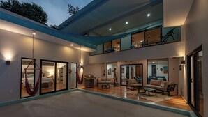 Ein modernes, mehrgeschossiges Haus mit einem großzügigen Wohnbereich, einem Balkon und einem Essbereich.