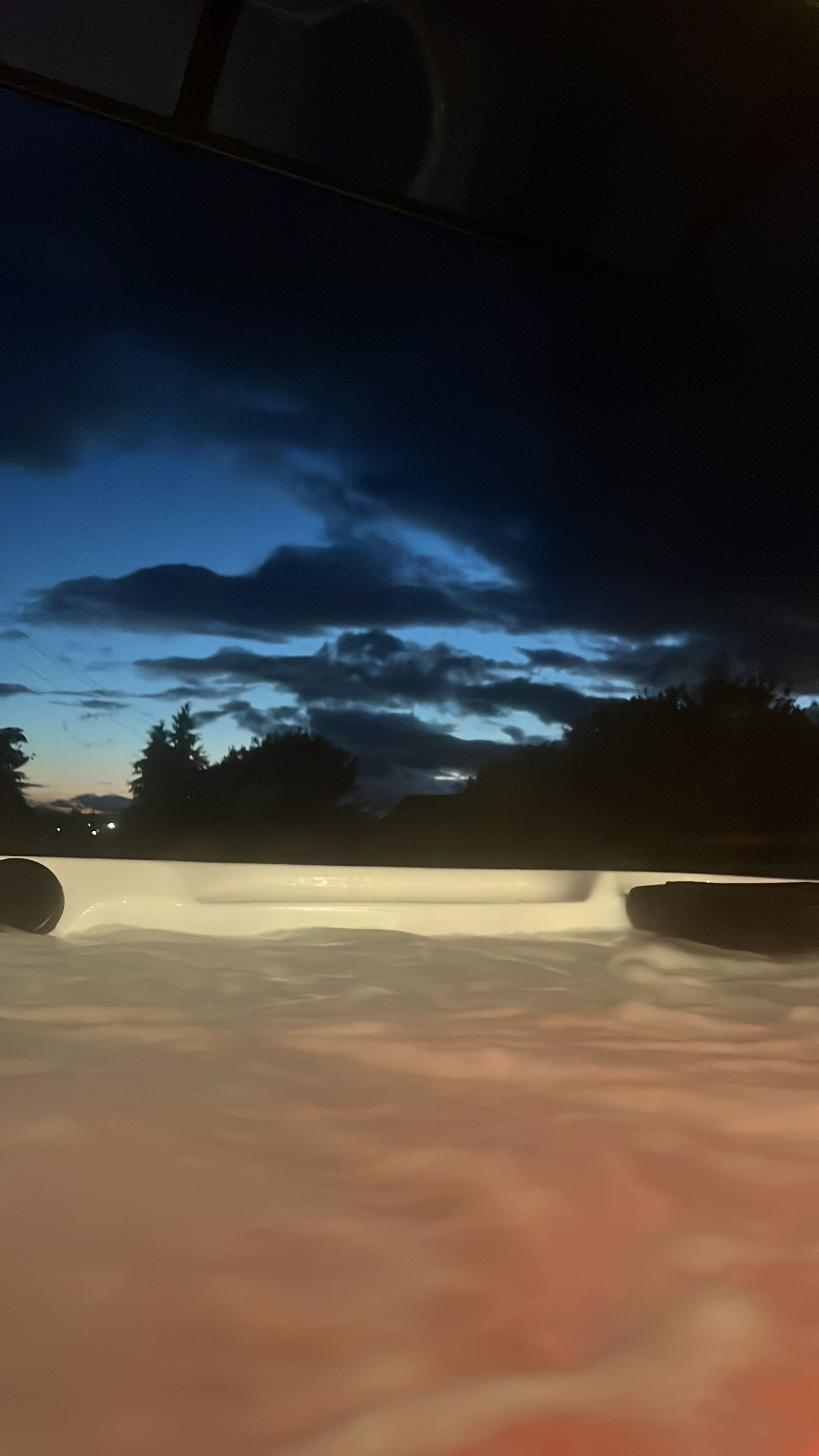 A hot tub with a view of the sky and trees.