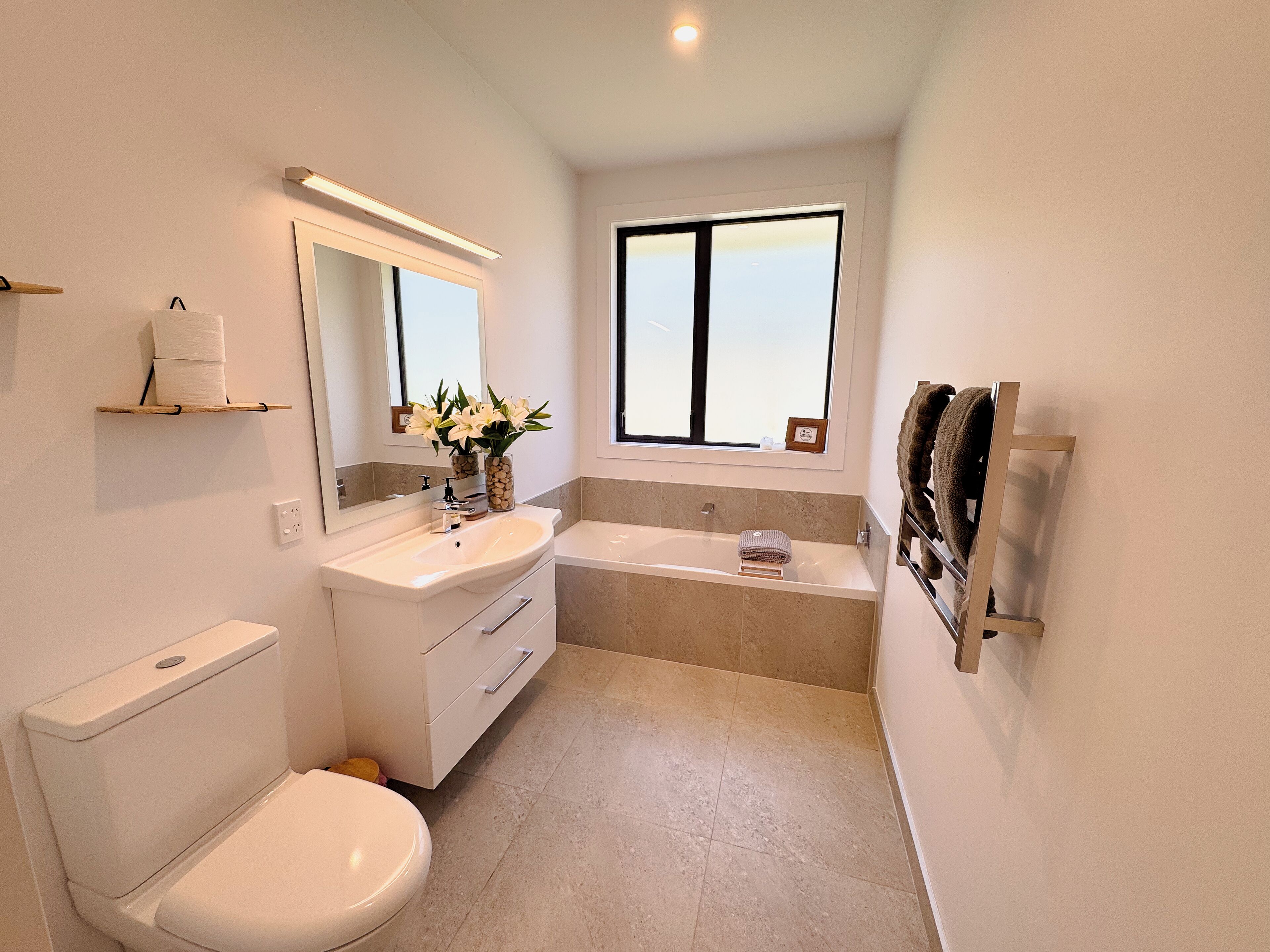 A modern bathroom with a toilet, sink, and bathtub.