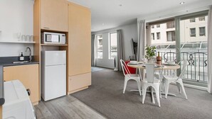 A modern apartment with a kitchen, dining area, and balcony. - Perfect City Retreat 1 bdrm Prime Location (Christchurch)