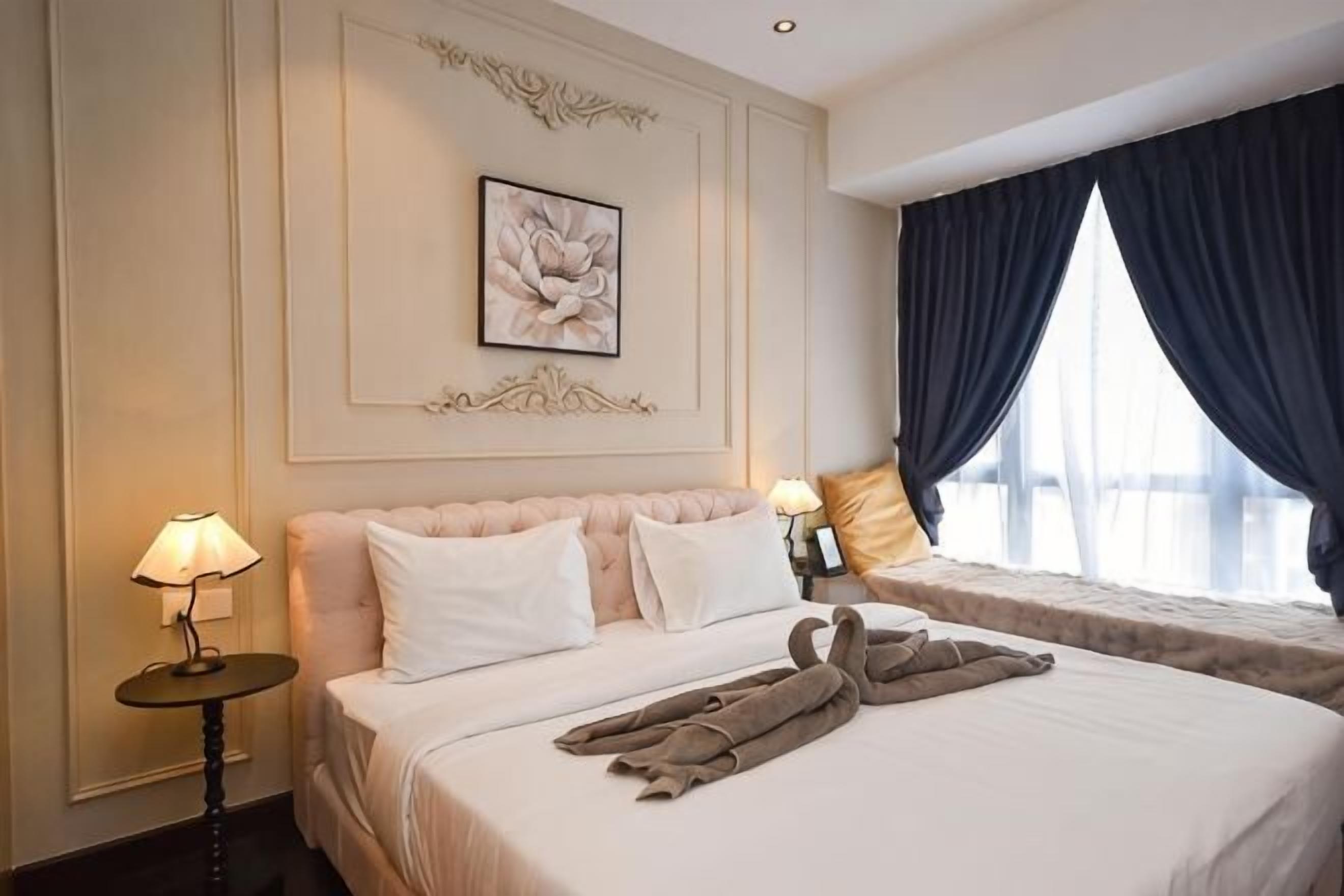 Habitación de hotel con cama, lámparas de noche, ventana con cortinas e imagen en un marco en la pared.
