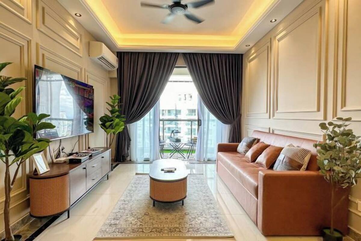 A modern living room with a sofa, a coffee table, a TV, and a ceiling fan.