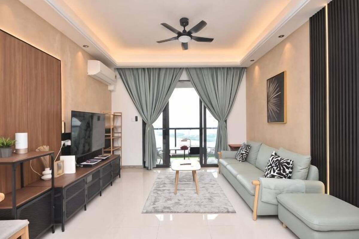 A modern living room with a sofa, TV, and a ceiling fan.