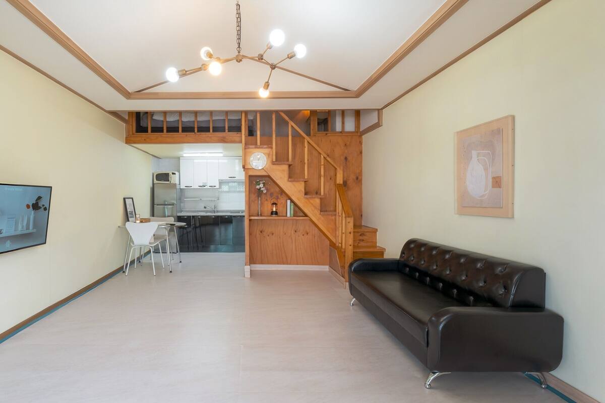 Ein geräumiger Wohnbereich mit moderner Küche, einer Treppe und einem Essbereich.