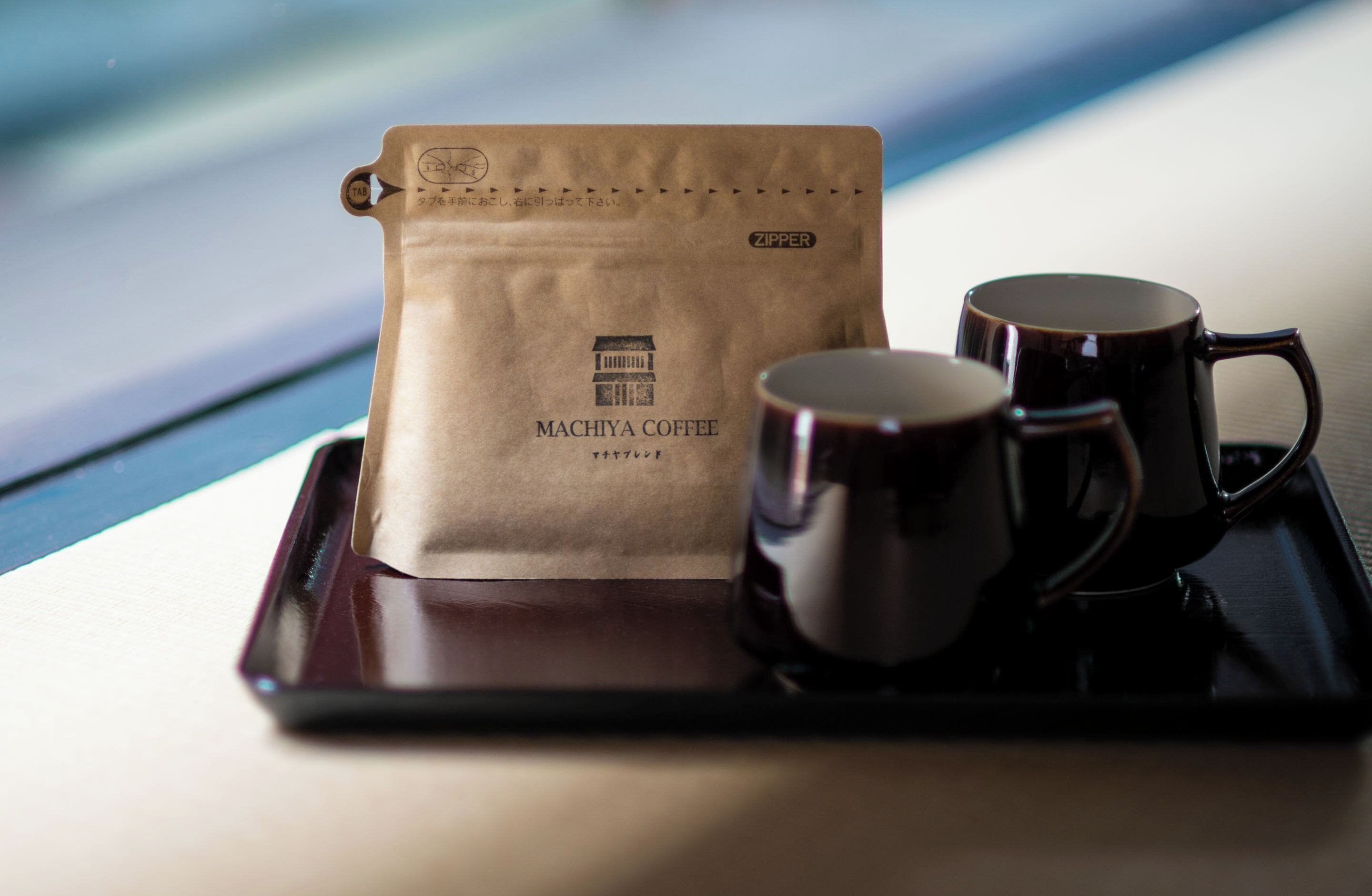 A tray with a coffee bag and two mugs.