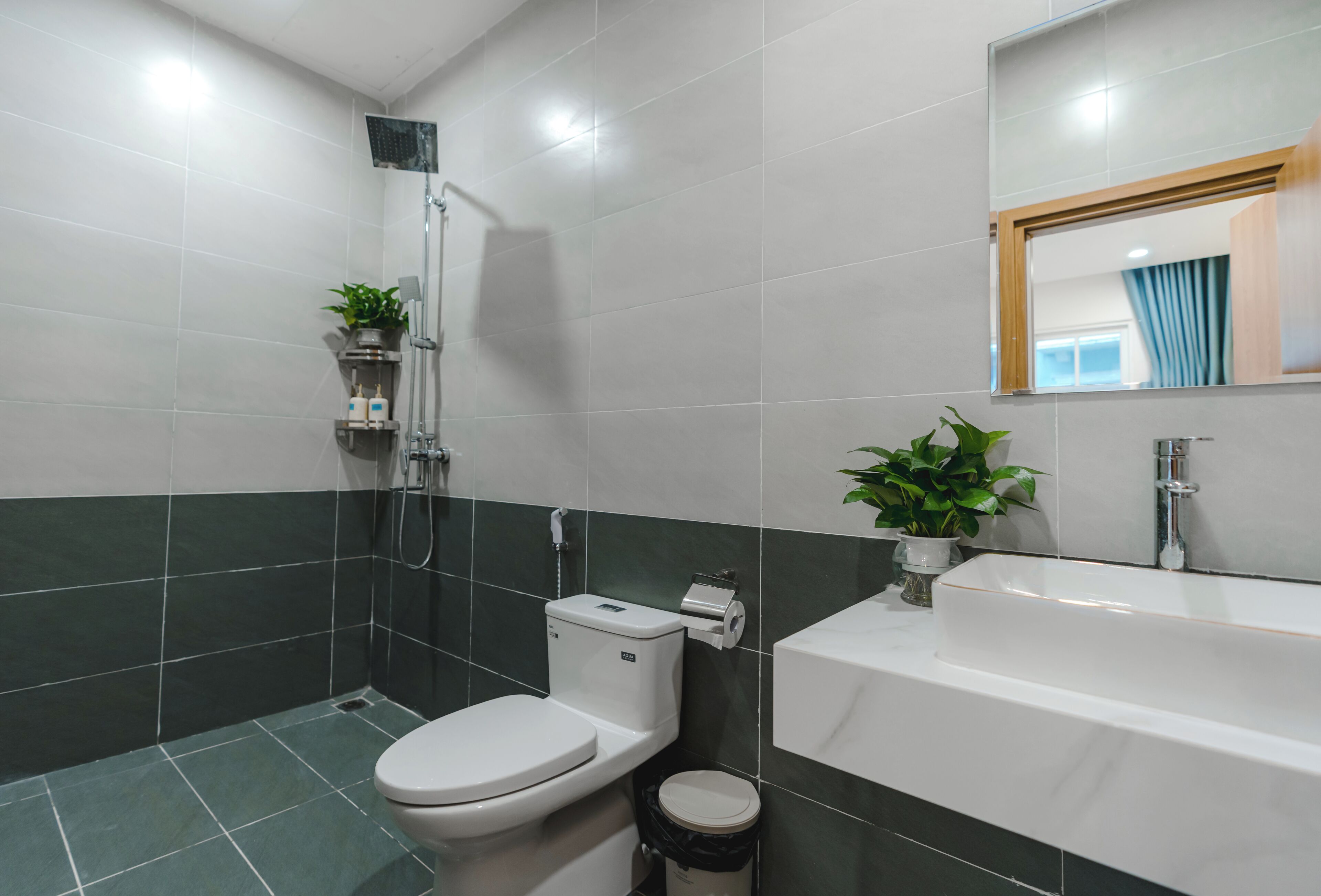 Un bagno con toilette, doccia, lavandino e specchio.