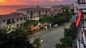 A coastal town at sunset with buildings, a street, and a view of the sea. - Rosy Hotel (Phu Quoc)