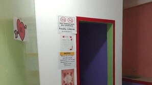 A hallway with a green door, a notice about no smoking, and a red and green wall. - WJV INN CORDOVA 1 (Cordova)
