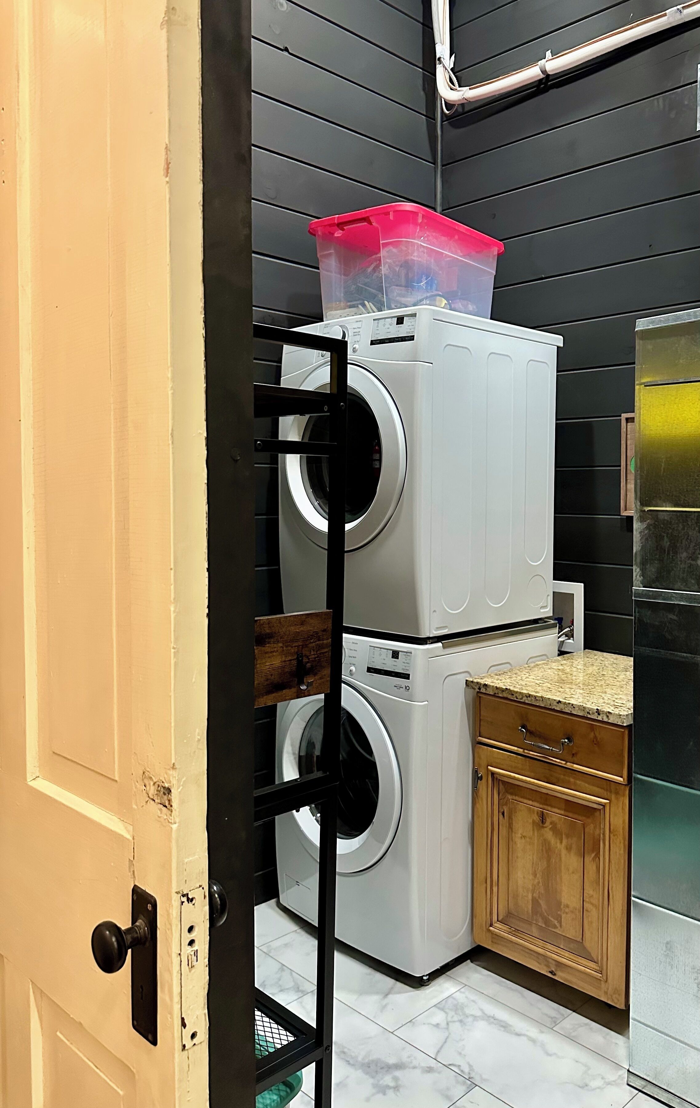 A laundry area with stacked washing machines and a countertop.
