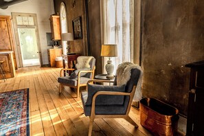 A cozy room with wooden flooring, a patterned rug, and a rustic aesthetic. - Light Filled Loft on Town Square. (Carlinville)